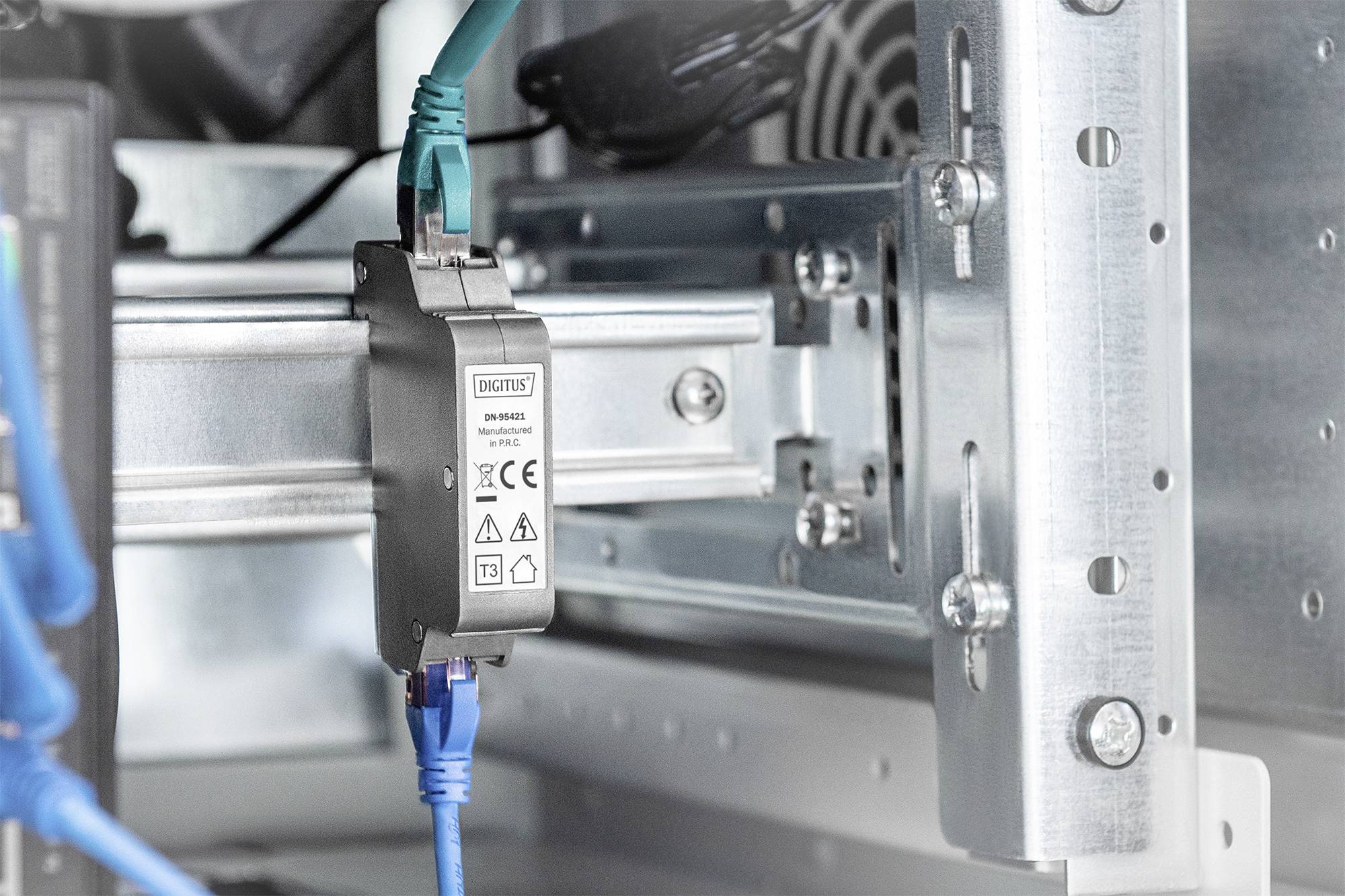 Ein Netzwerkverteiler in einem Servergehäuse mit mehreren verbundenen Kabeln. Ein Gerät trägt das CE-Zeichen und Warnsymbole.