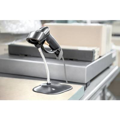 Ein Barcode-Scanner steht auf einem Tisch in einem Geschäftsumfeld, umgeben von Kartons.