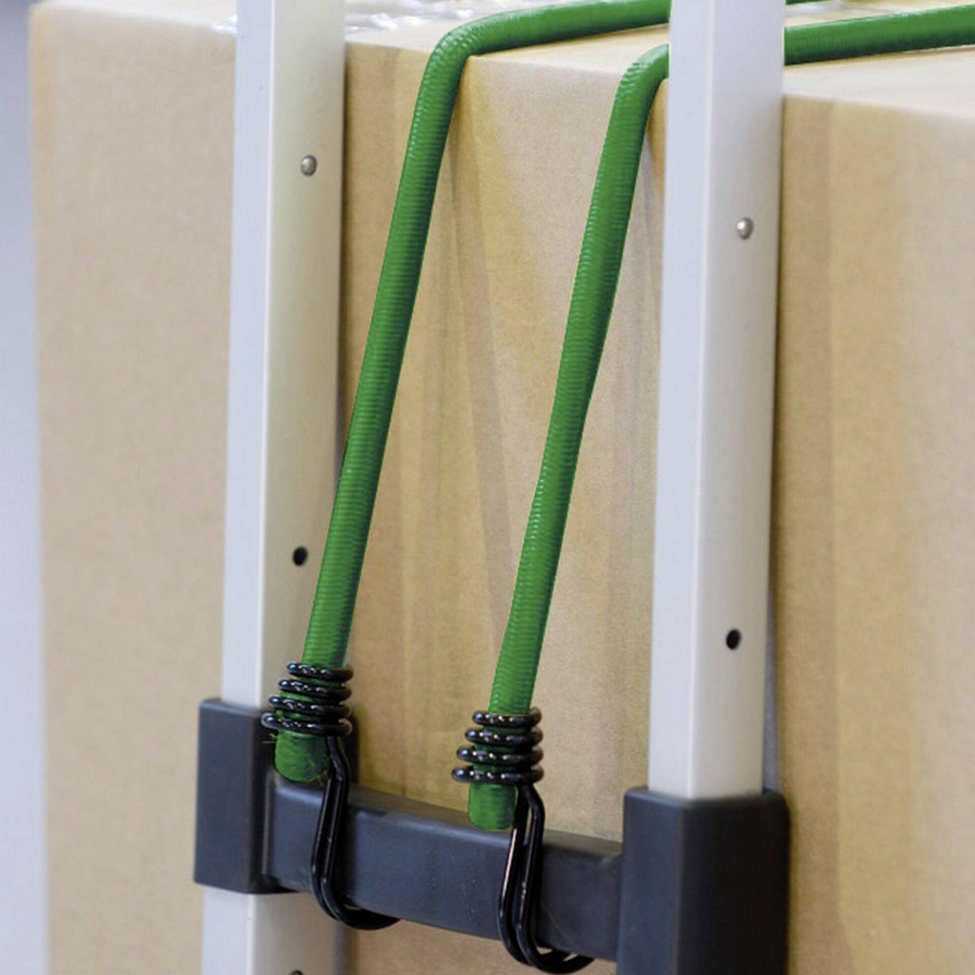 Grüner Spanngurt sichert ein Paket auf einem Handwagen.