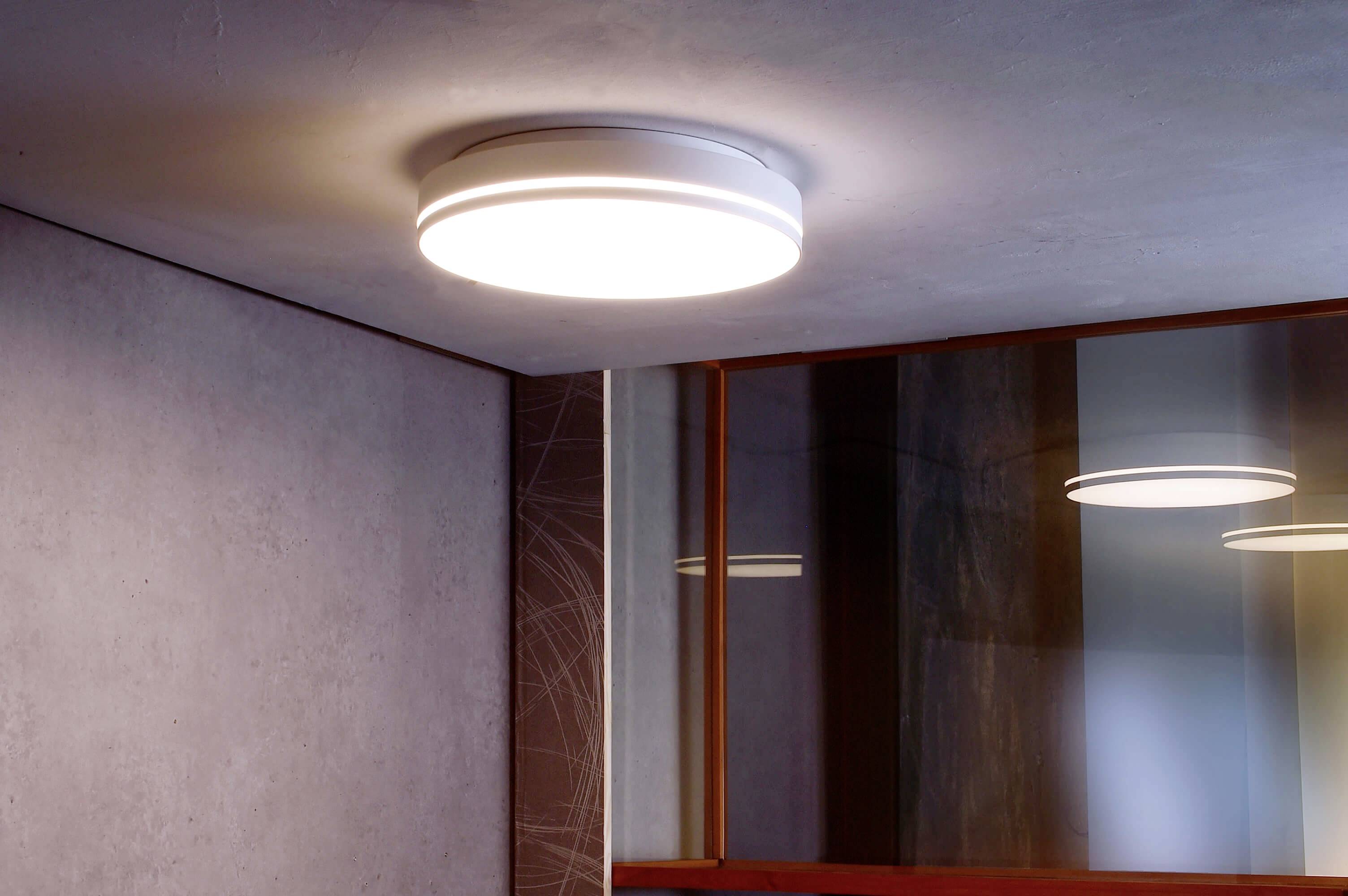 Eine runde Deckenleuchte ist an der Decke eines Raumes montiert und leuchtet hell, um den Raum zu erhellen.