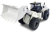 Ein weißer Radlader mit großer Schaufel, bereit zum Beladen von Materialien auf einer Baustelle.