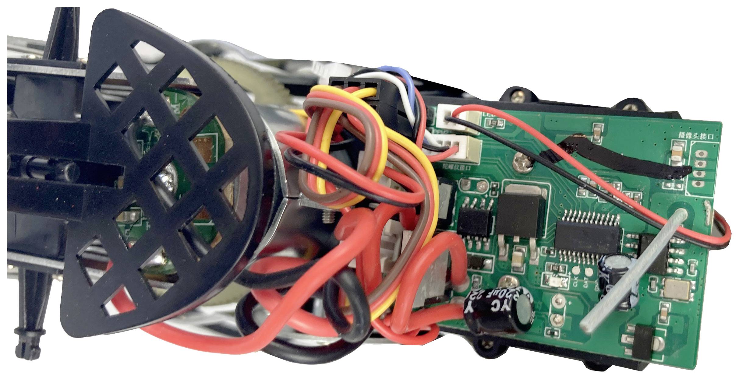Nahaufnahme einer elektronischen Leiterplatte mit mehreren farbigen Kabeln und verschiedenen Komponenten, darunter ein schwarzer Lüfter.