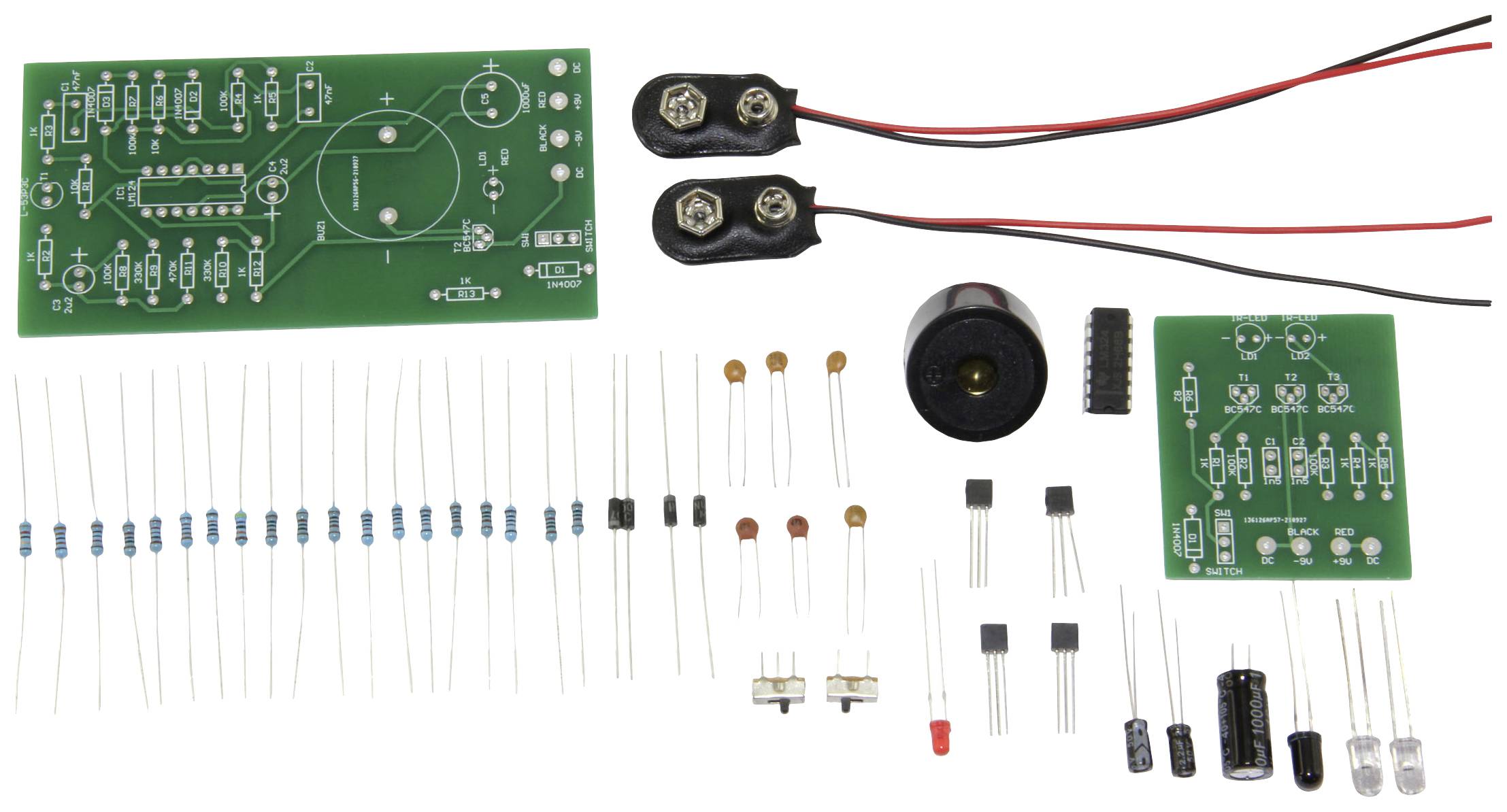 Elektronik-Bausatz mit Leiterplatten, Widerständen, Kondensatoren, Schaltern und Batterieklemmen, bereit zur Montage.