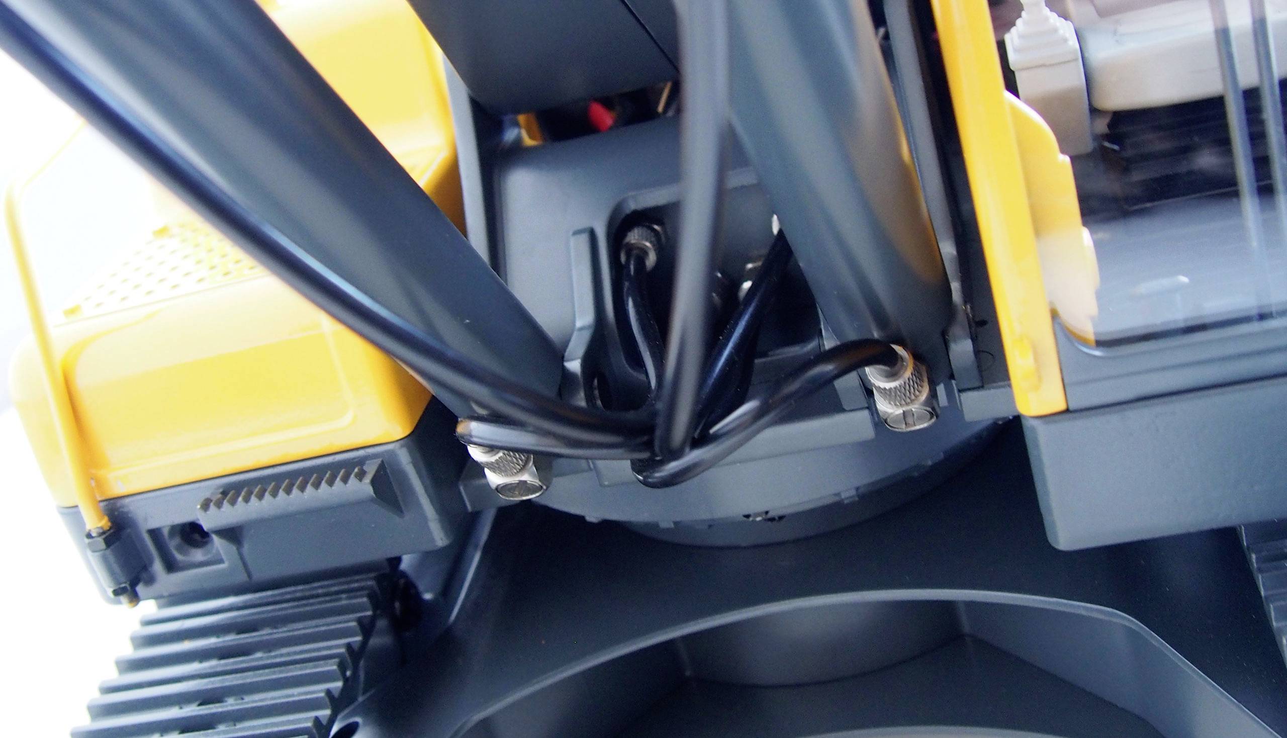 Nahaufnahme eines gelben Bagger-Spielzeugs aus Kunststoff, das mechanische Teile und Hydraulikzylinder zeigt. Gerät für Kinder.