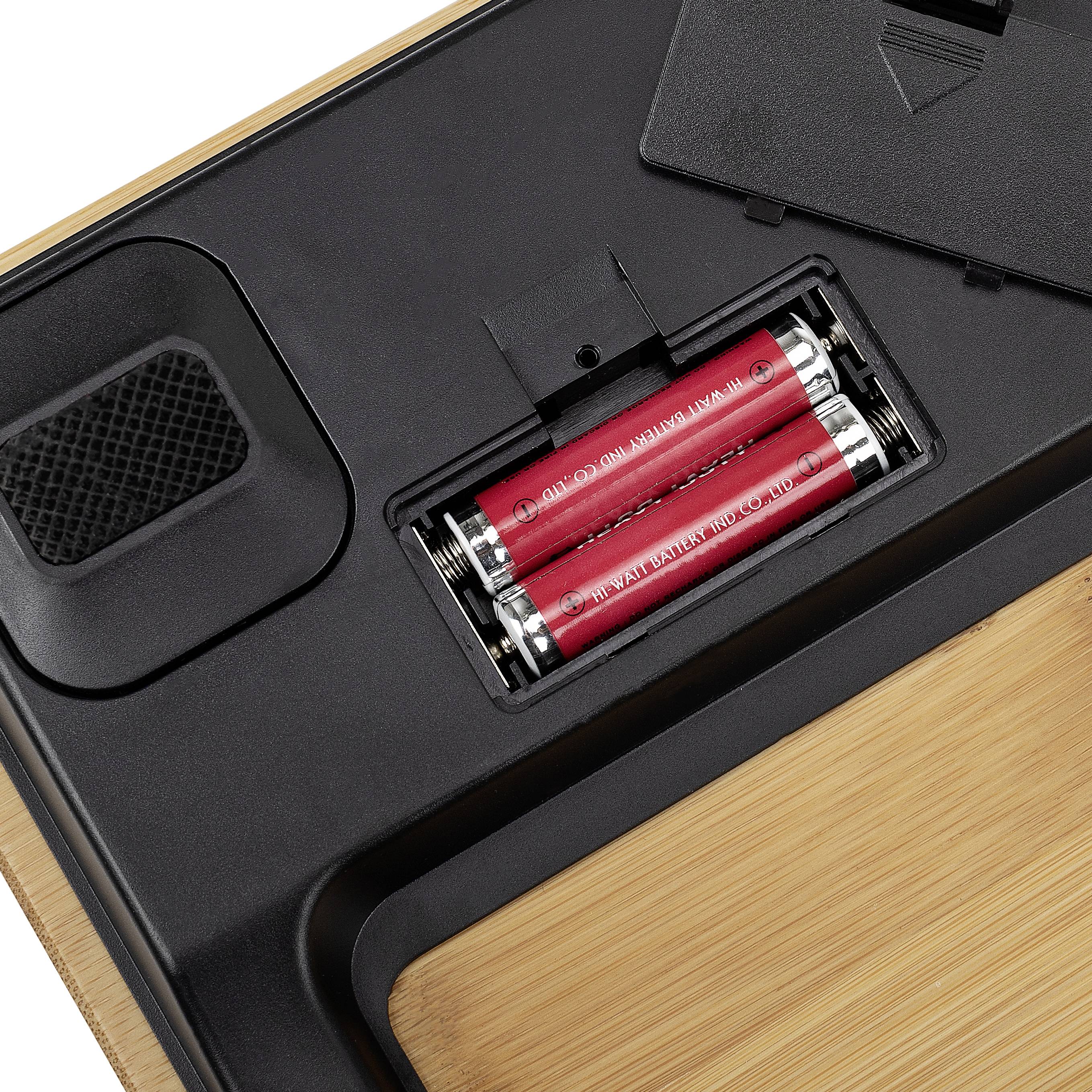 Die Abbildung zeigt das Batteriefach einer elektronischen Waage mit eingelegten Batterien.