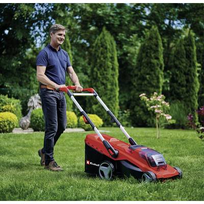 Ein Mann mäht den Rasen mit einem roten elektrischen Rasenmäher in einem gepflegten Garten. Im Hintergrund sind Sträucher und Bäume.
