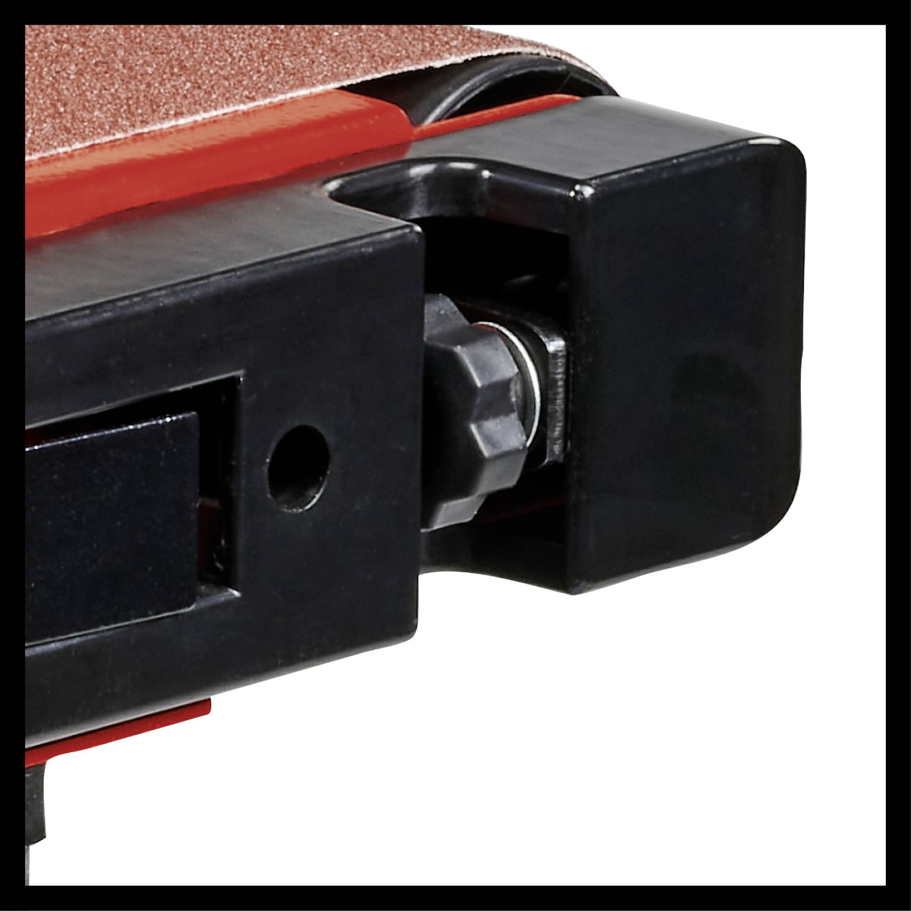 Nahaufnahme eines Schleifbandes einer Maschine. Der schwarze Rahmen und rote Gummi sind deutlich sichtbar. Fokus auf Mechanik.