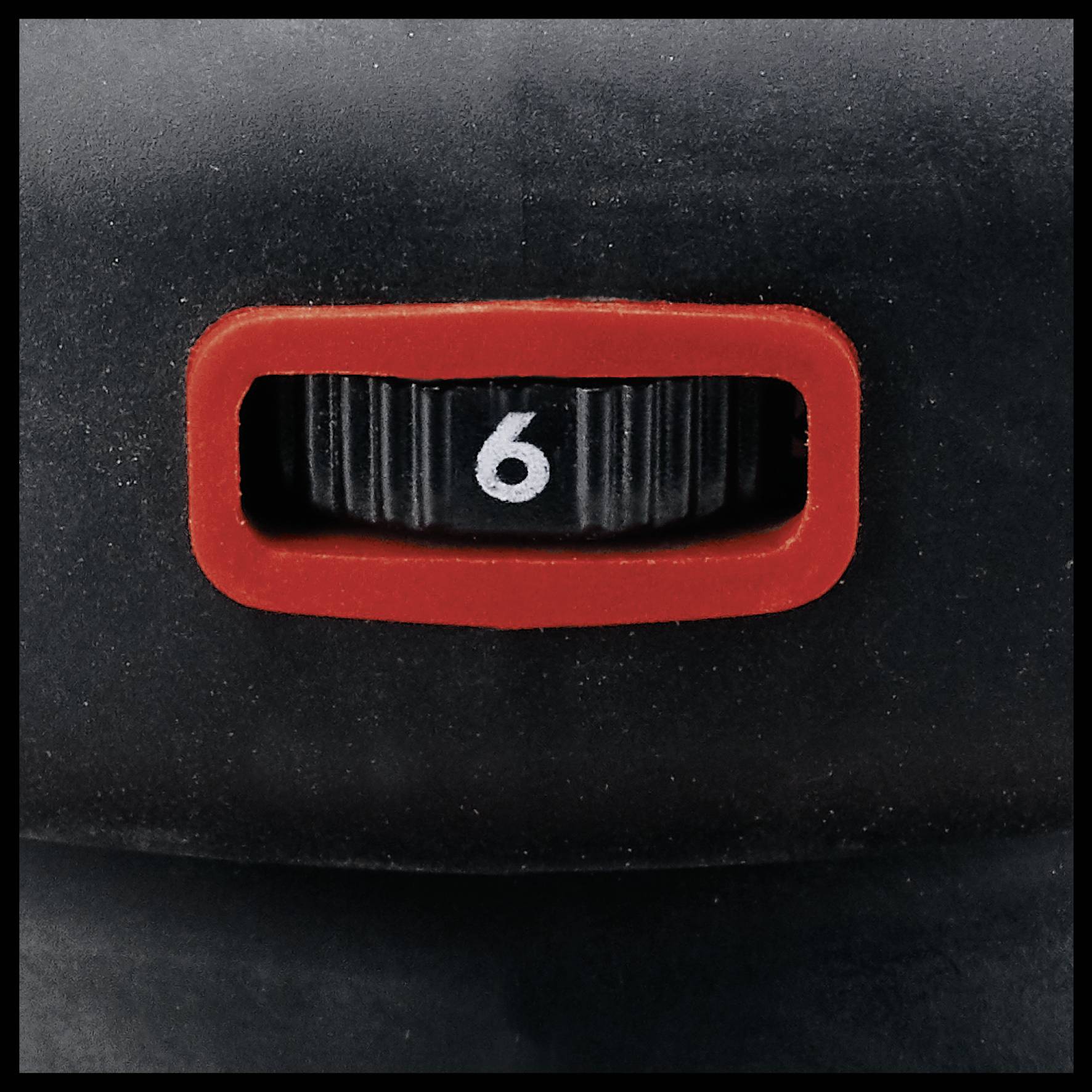 Nahaufnahme eines schwarzen Ziffernrads, das die Zahl '6' anzeigt, umgeben von einem roten Rahmen.