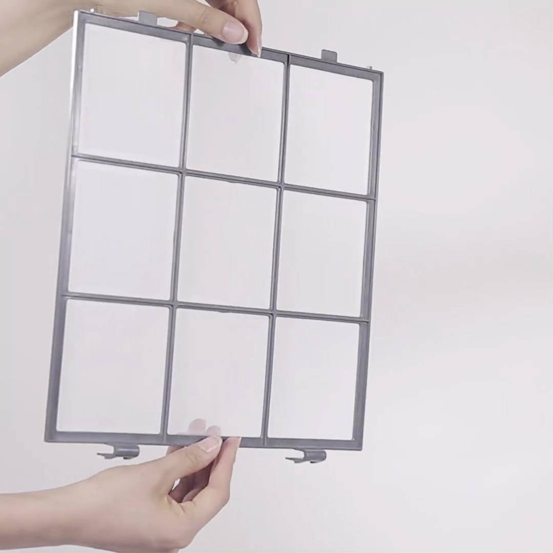 Eine Person hält einen rechteckigen Filter mit neun quadratischen Gitterfeldern in die Kamera. Der Hintergrund ist neutral weiß.