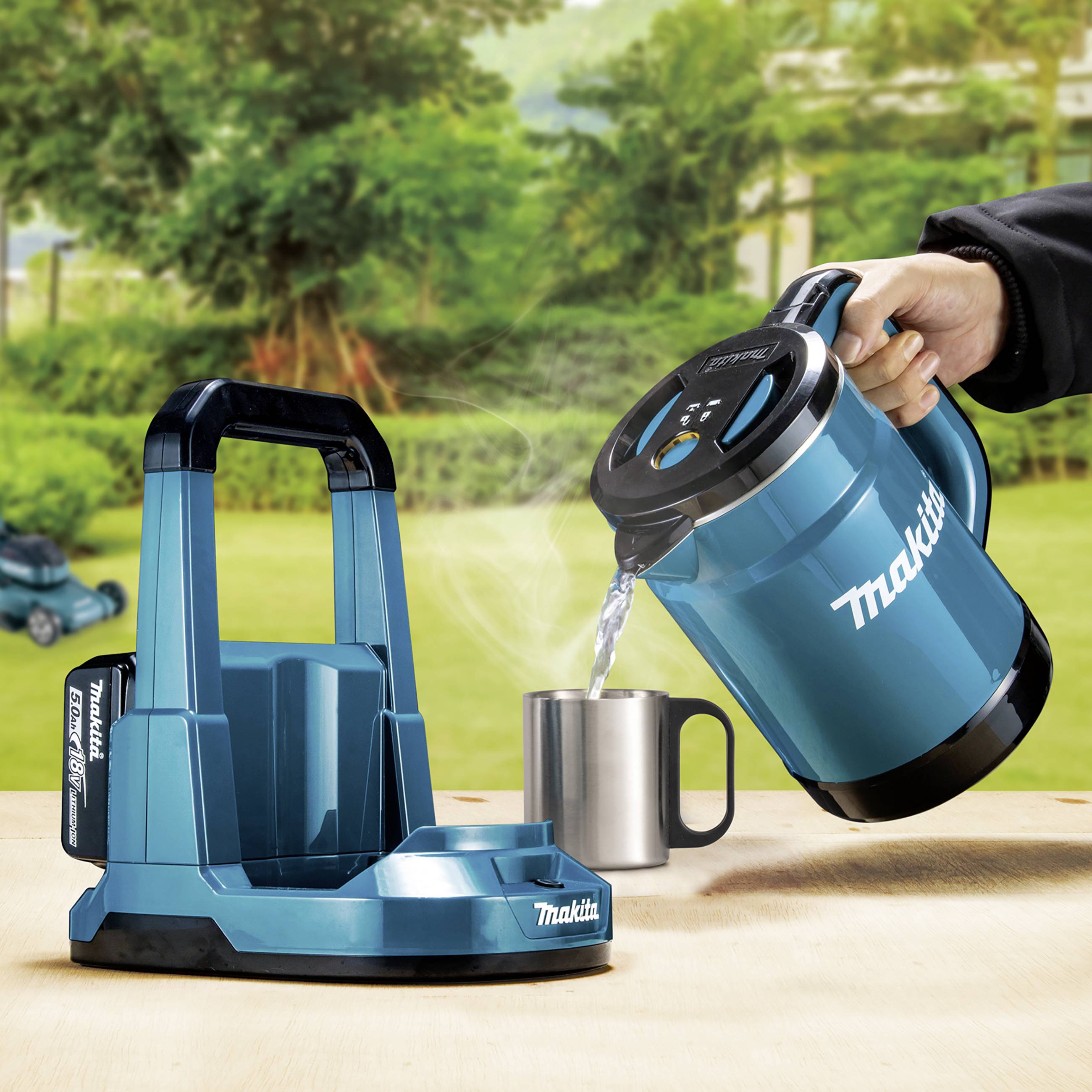 Ein elektrischer Wasserkocher von Makita, der in eine silberne Tasse Wasser gießt; Umgebung zeigt einen grünen, bewaldeten Garten.