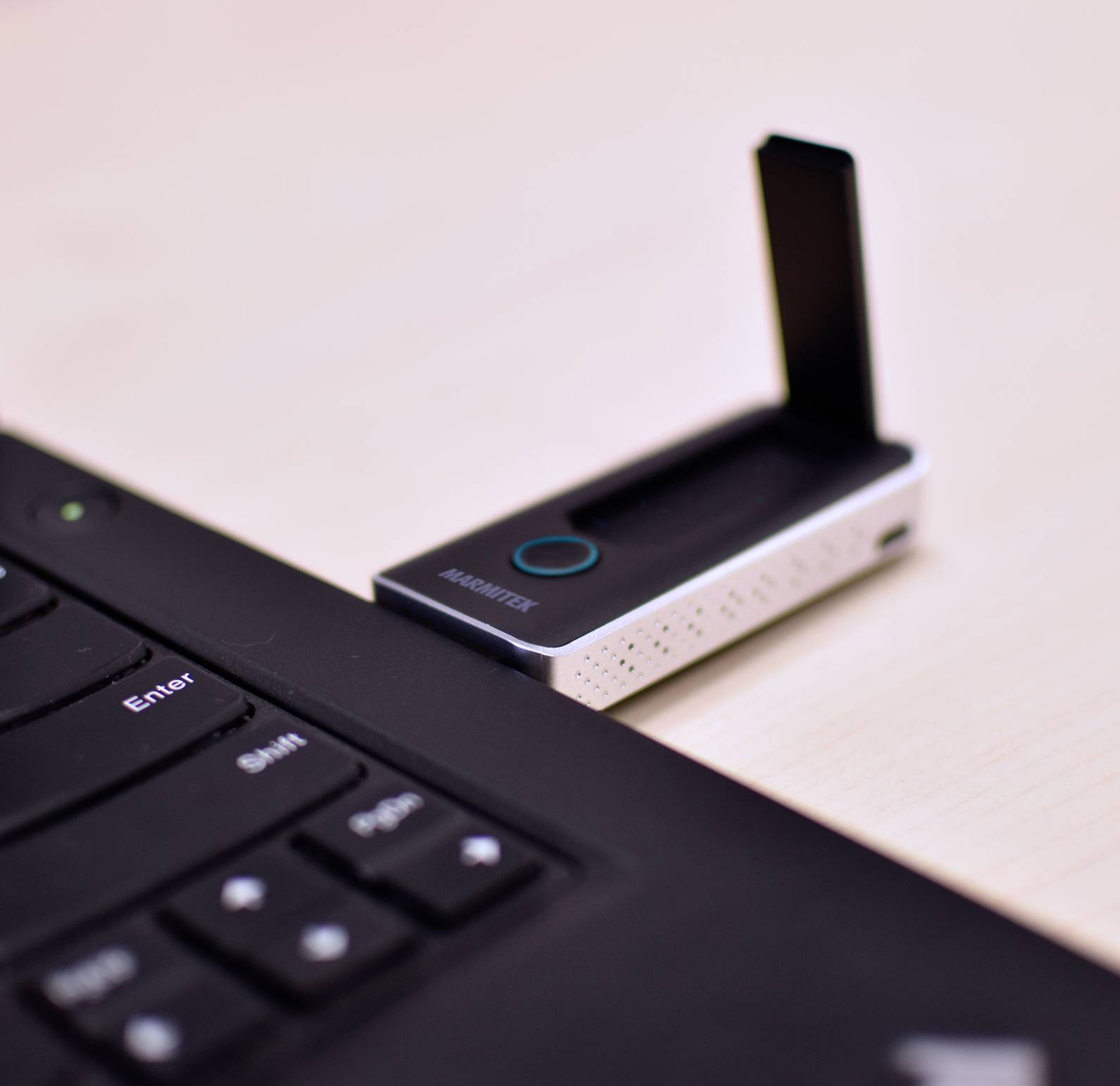 Ein USB-Stick ist in einen Laptop gesteckt. Der Stick ist schwarz-weiß mit einer Aufschrift auf der Vorderseite.