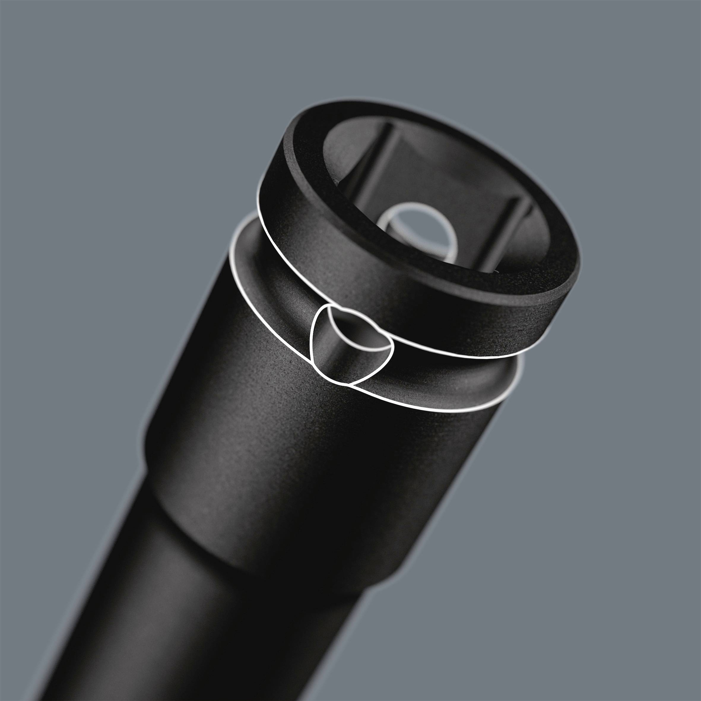 Schwarzes Metallobjekt mit einem zylindrischen Design und einer kleinen Öffnung an einem Ende, auf grauem Hintergrund.