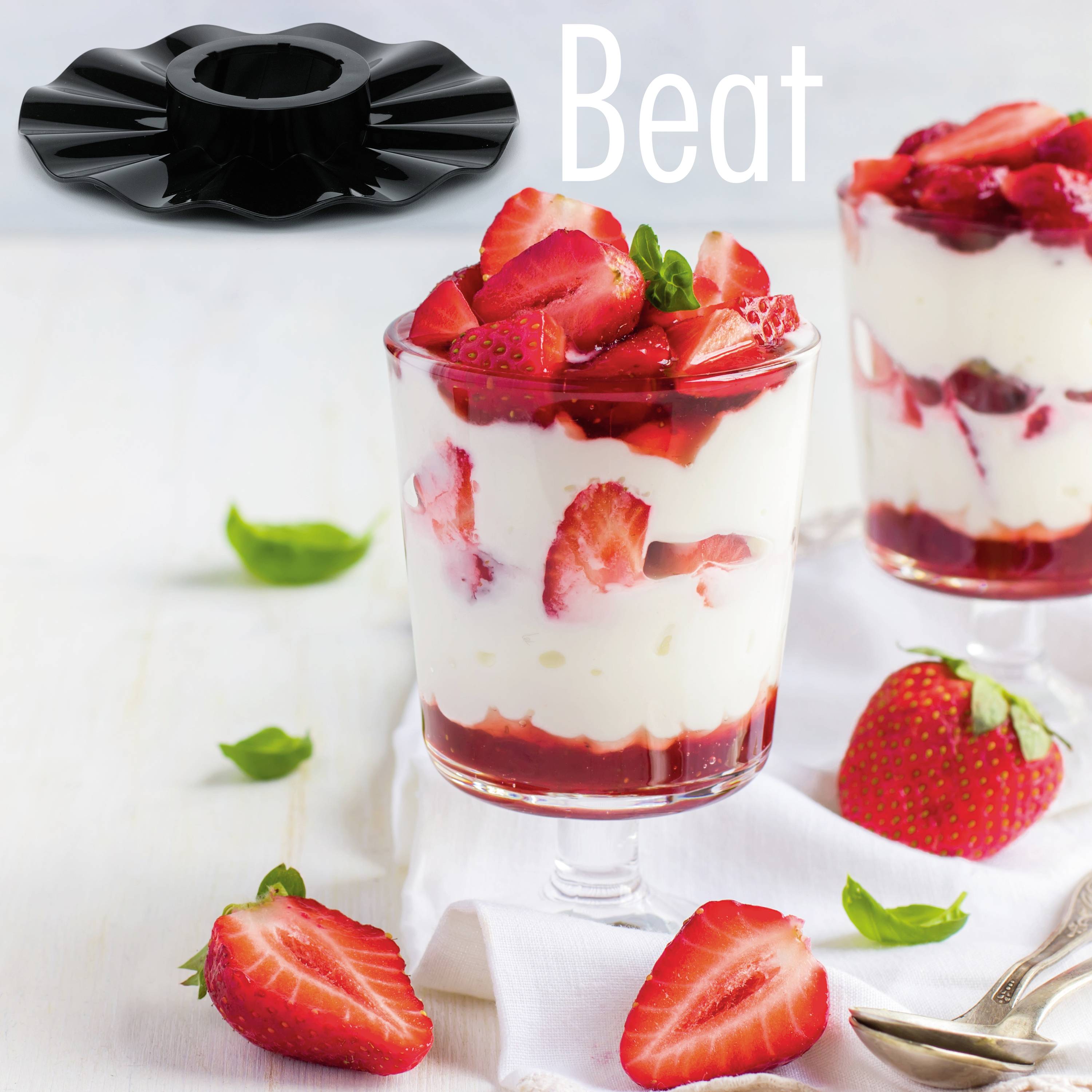 Ein Dessertglas gefüllt mit Schichten aus Joghurt und frischen Erdbeeren, garniert mit Minze. Daneben liegen ganze und geschnittene Erdbeeren.