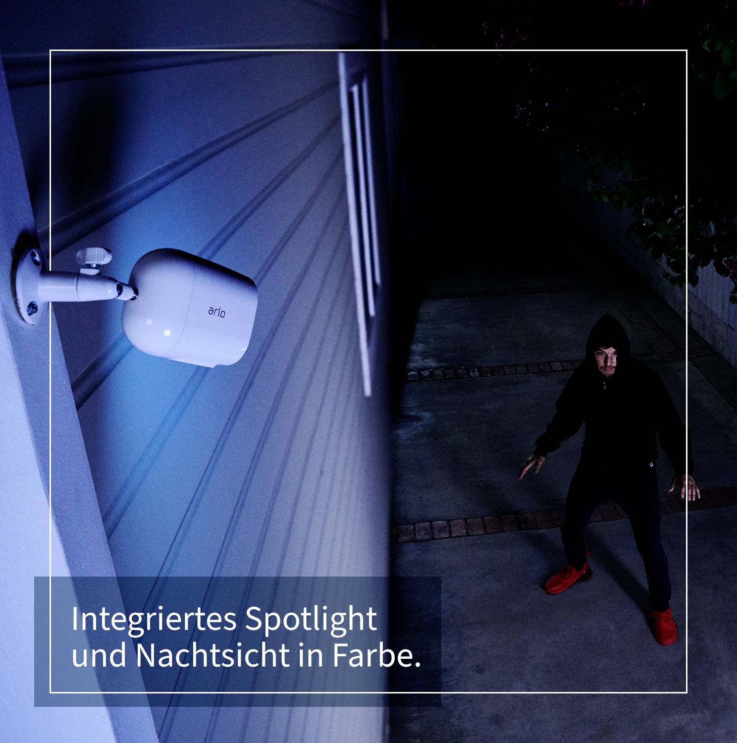 Nachtszene mit Sicherheitskamera, die einen beleuchteten Bereich überwacht. Text: 'Integriertes Spotlight und Nachtsicht in Farbe.'