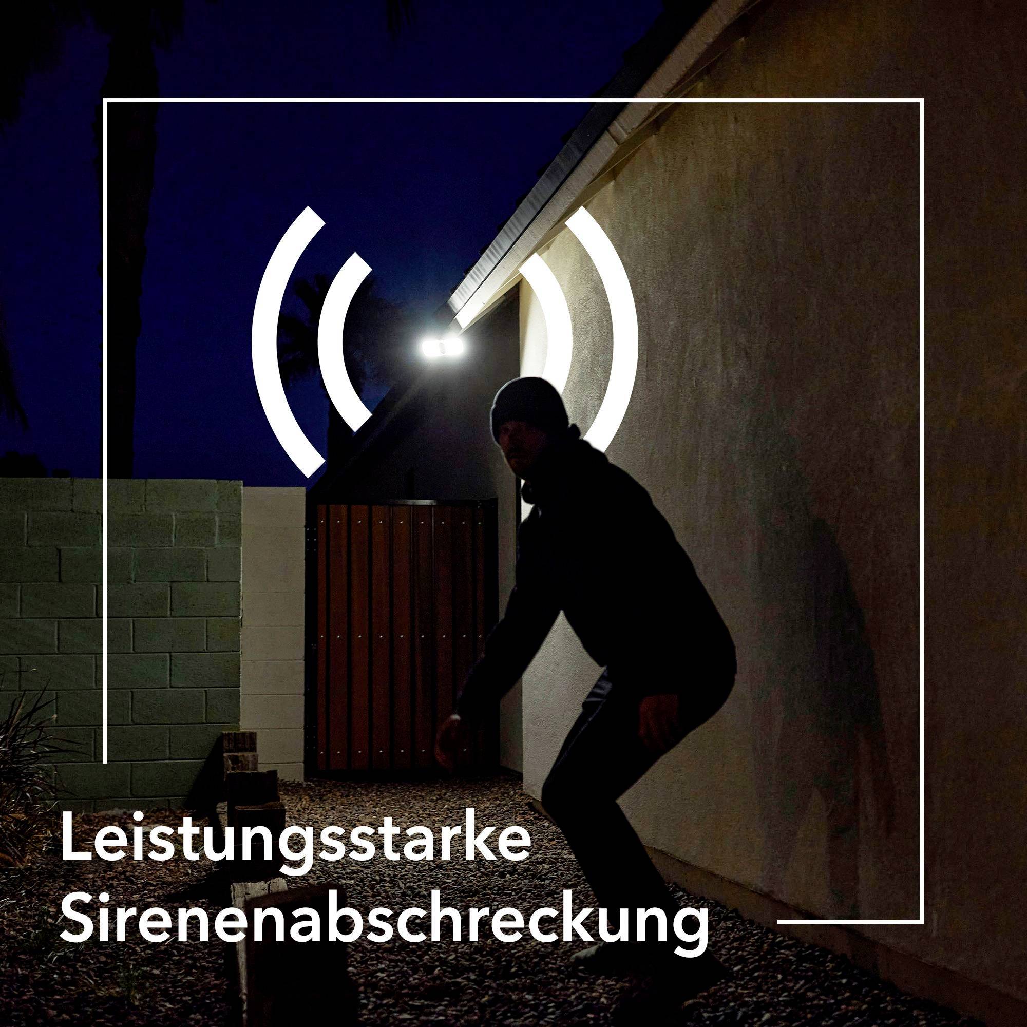 Eine Person in dunkler Kleidung nähert sich einem beleuchteten Eingang. Text: 'Leistungsstarke Sirenenabschreckung'.