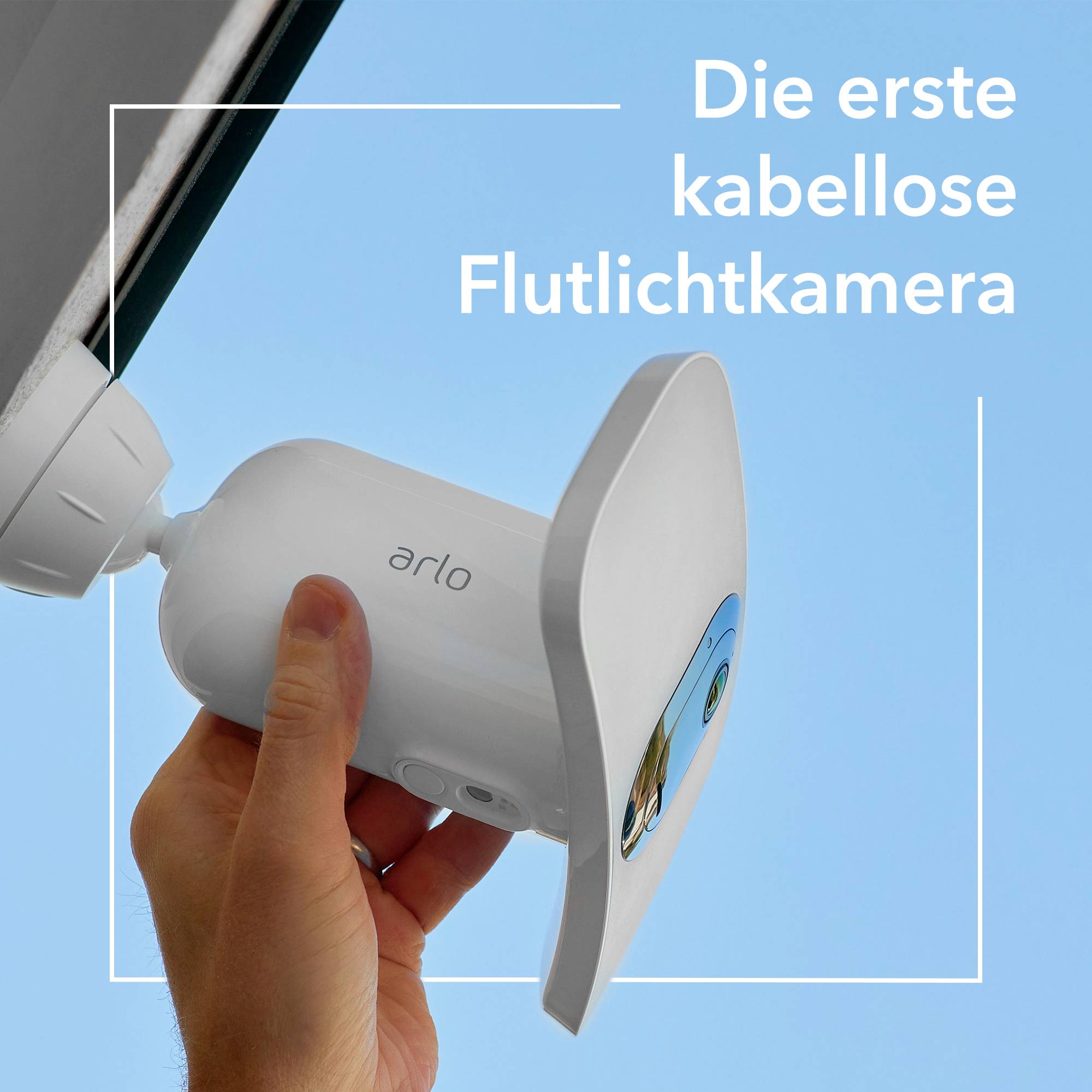 Eine Hand hält eine kabellose Flutlichtkamera unter einem Gebäudedach. Text: 'Die erste kabellose Flutlichtkamera'.