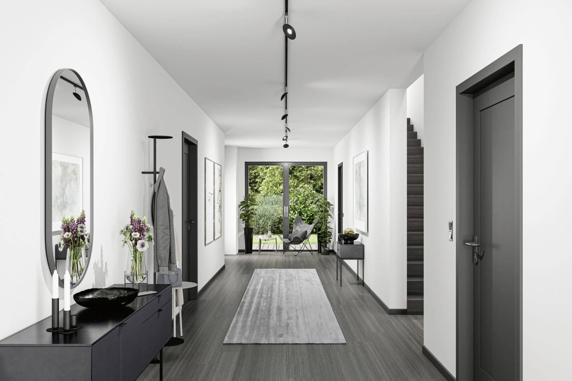 Langer Flur eines modernen Hauses mit dunklen Möbeln, einem Spiegel, Wandbildern und Blick auf einen Garten im Hintergrund.