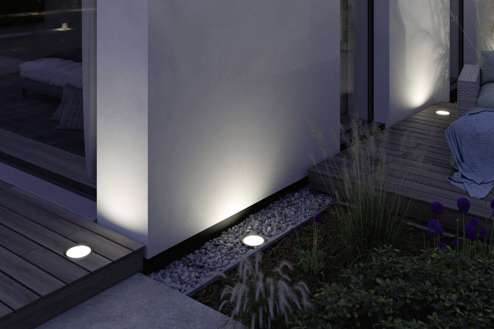 Beleuchteter moderner Terrassenbereich mit eingebauten Bodenleuchten, die eine gemütliche Abendatmosphäre schaffen.