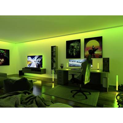 Ein moderner Gaming-Raum mit grünem und gelbem Licht, Schreibtisch, Gaming-Stuhl, Computer, großem Fernseher und dekorativen Postern an der Wand.