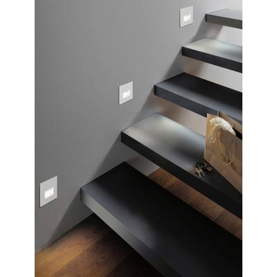 Eine modern gestaltete Treppe mit seitlich angebrachten Lichtern. Auf der Stufe liegt eine braune Einkaufstasche und ein Schlüsselbund.