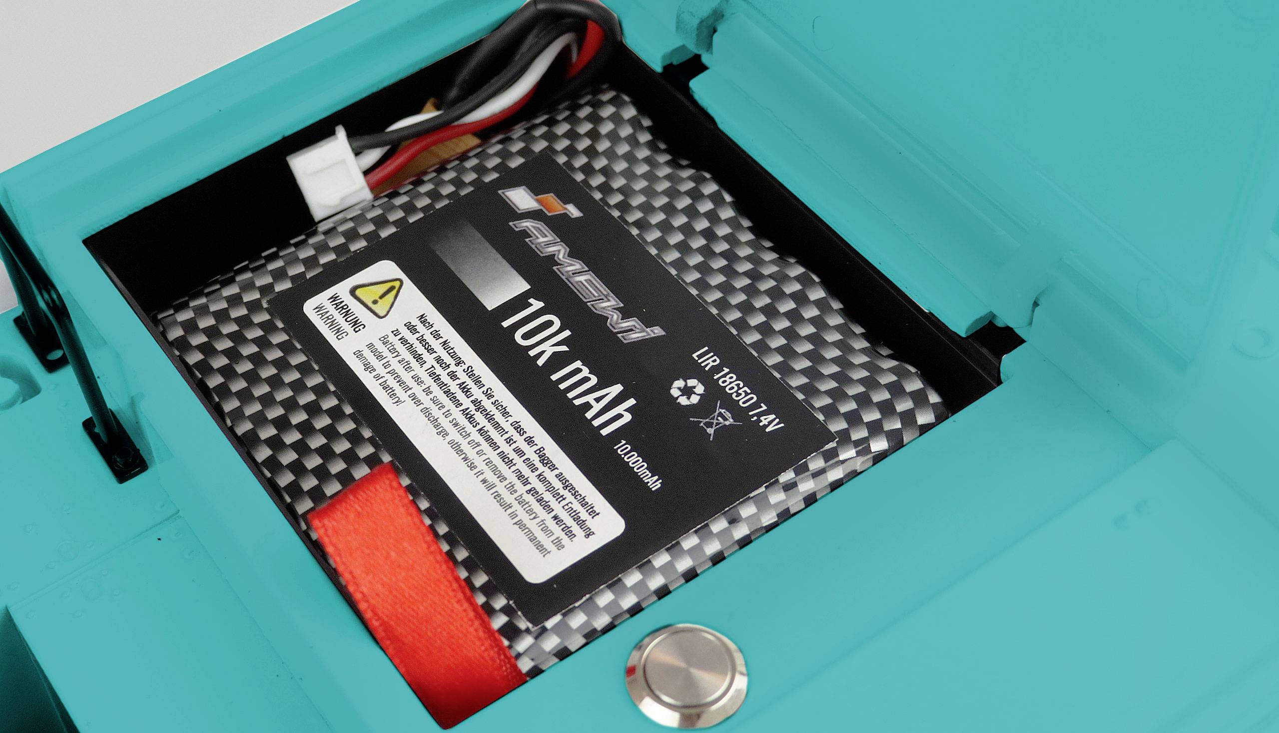 Ein 10.000 mAh Akku liegt in einem blauen Gehäuse. Kabel sind sichtbar, und ein Warnhinweis ist auf dem Etikett des Akkus.
