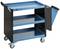Blauer Werkstattwagen mit drei Ablageflächen, schwarzen Seitengittern und vier Rädern. Auf der rechten Seite ein angeschlossener Müllbehälter.