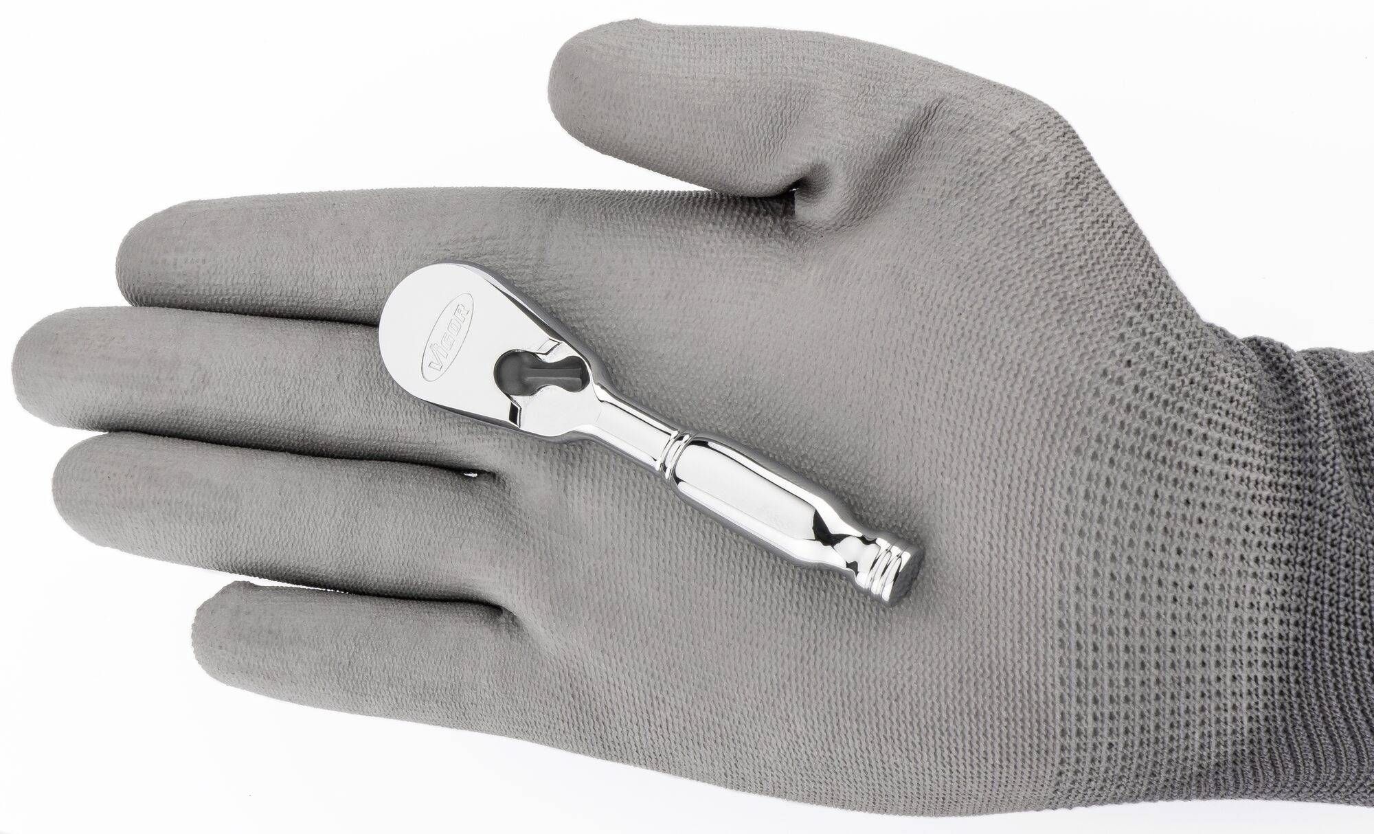 Eine graue, behandschuhte Hand hält einen kleinen, glänzenden Schraubenschlüssel.