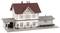 Gebäude eines alten Bahnhofs mit rotem Dach und weißer Fassade, beschriftet mit 'Owen Teck'. Angrenzende Güterhalle rechts.