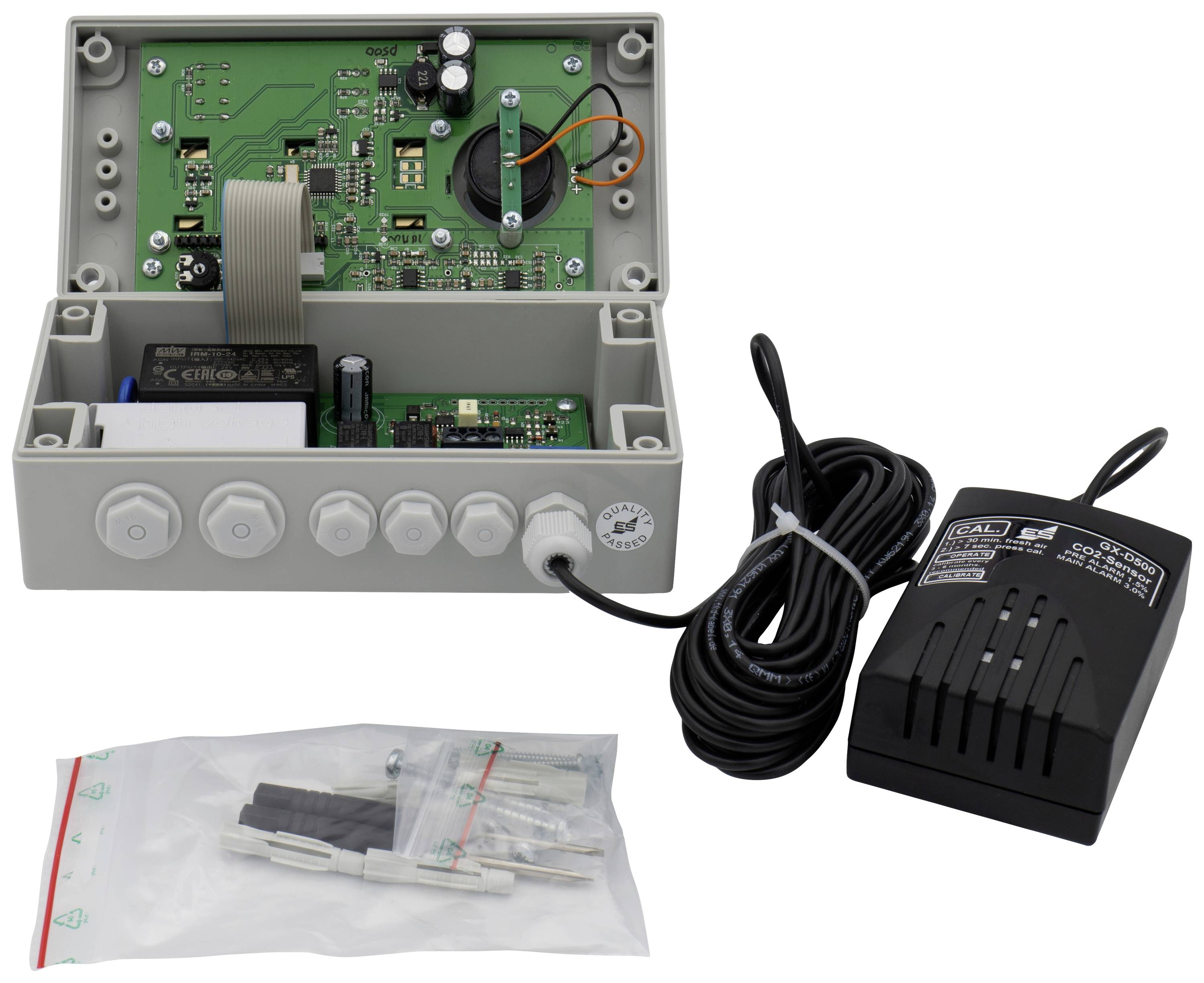 Ein geöffnetes elektronisches Gerät mit Kabeln und Leiterplatten. Daneben liegen ein Netzteil und Montagematerial in einem Beutel.