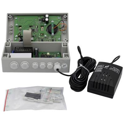 Ein geöffnetes elektronisches Gerät mit Kabeln und Leiterplatten. Daneben liegen ein Netzteil und Montagematerial in einem Beutel.
