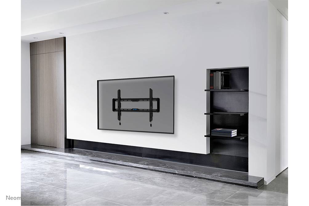 Wand in modernem Raum mit flachem Fernseher an Wandhalterung, links Tür, rechts Regal mit Büchern. Minimalistische Einrichtung.