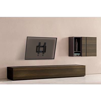 Ein schwenkbarer Fernseher ist an einer Wand mit einem Holzschrank montiert. Neben dem Fernseher befindet sich ein Regal mit Dekorobjekt.