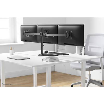 Drei Monitorbildschirme auf einem Halterungssystem auf einem modernen weißen Schreibtisch mit Tastatur, Maus und Stapel Bücher.