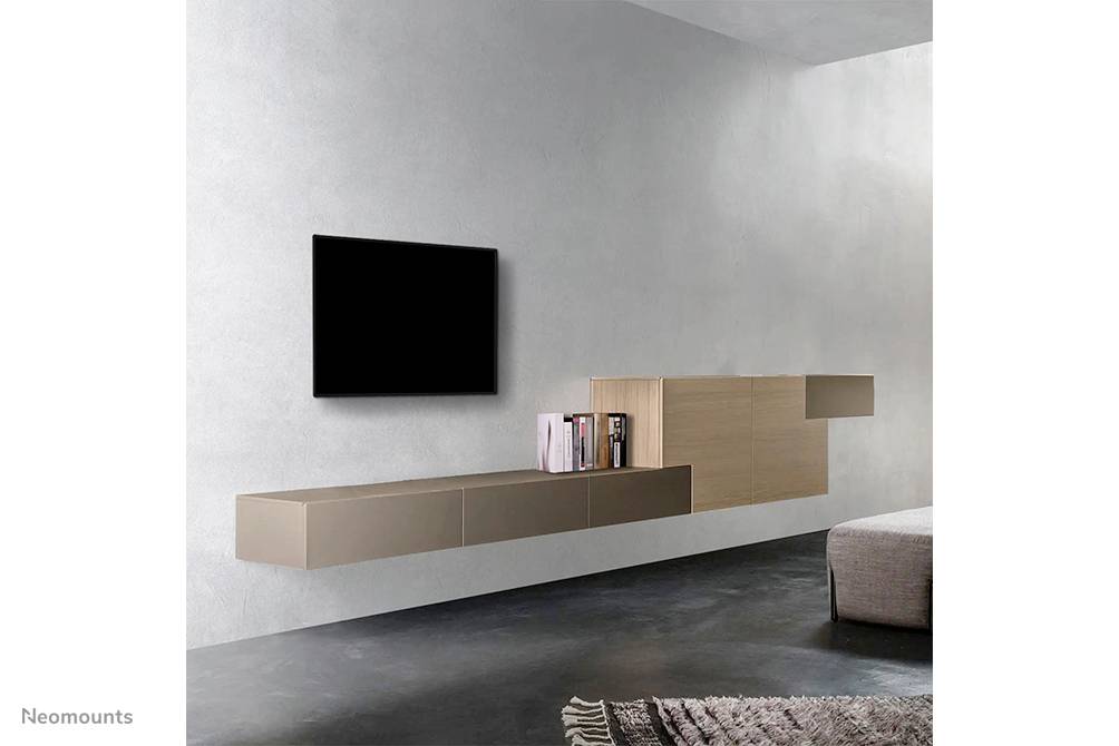Wandmontiertes, modernes Wohnzimmer-Setup mit schwebendem Fernseher, niedriger Konsole und Bücherregal, minimalistisches Design.