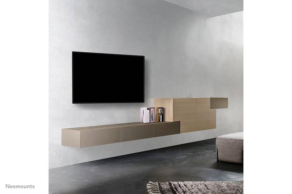 Wandmontierter Fernseher über einem modernen, schwebenden Regal mit Büchern in einem minimalistischen Wohnzimmer.
