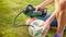 Person pumpt einen Fußball mit einer elektrischen Pumpe auf einem grünen Rasen auf. Hauptaugenmerk liegt auf der Handlung des Aufpumpens.