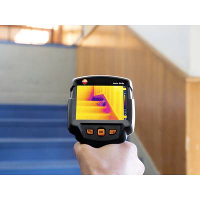 Eine Person hält eine Wärmebildkamera, die Treppen anvisiert. Der Bildschirm zeigt Temperaturunterschiede an den Stufen.