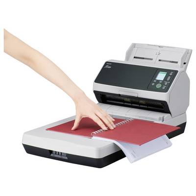 Ein Scanner mit geöffnetem Deckel scannt ein rotes spiralgebundenes Notizbuch, während eine Hand die Seiten justiert.