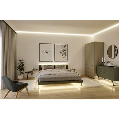 Ein modernes Schlafzimmer mit einem großen Bett, Pflanzen, Nachttischen, Kunst an der Wand, Schrank und Kommode mit Kerzen.