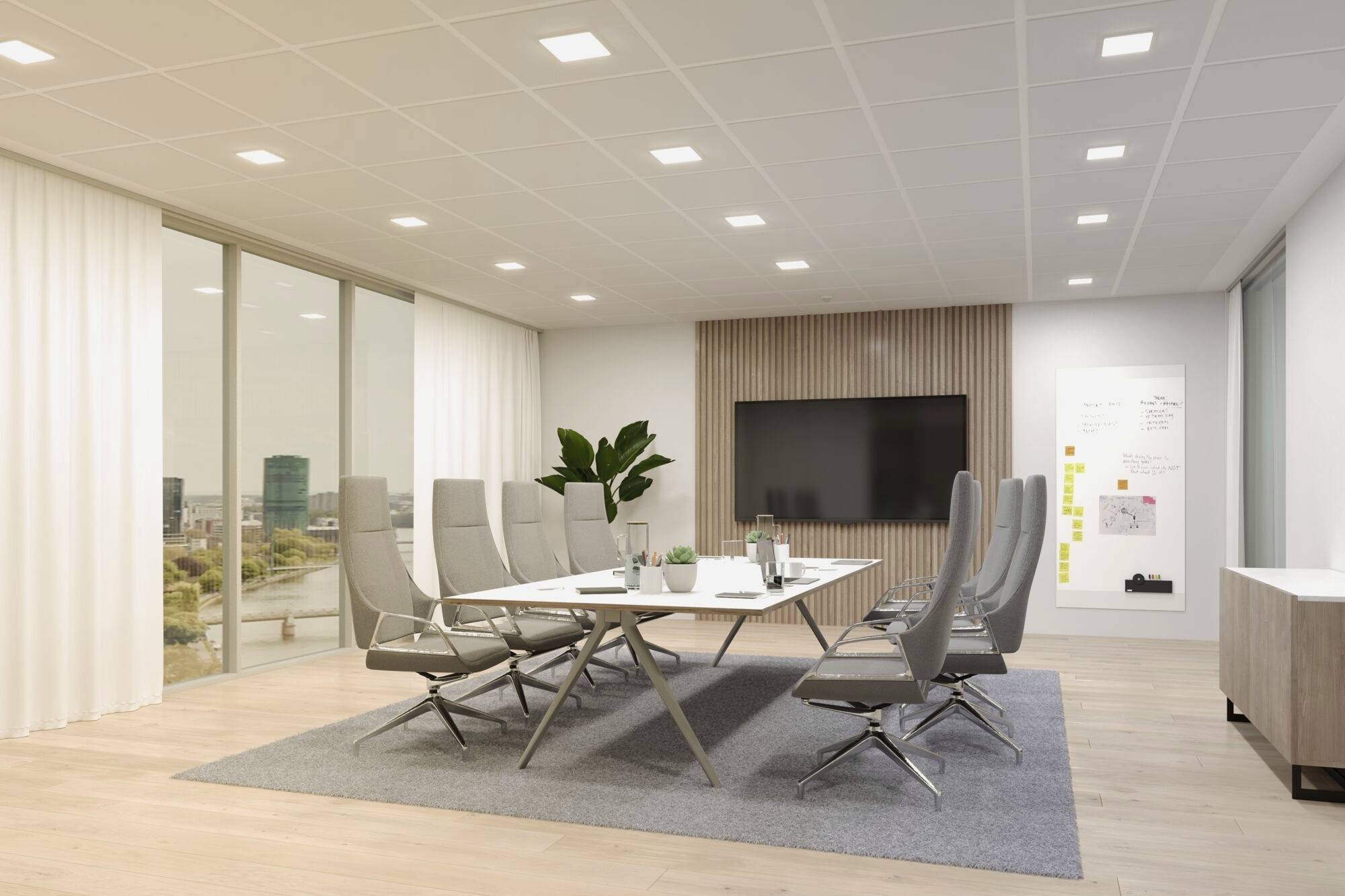 Moderner Konferenzraum mit großem Tisch, mehreren Stühlen, Flachbildfernseher an der Wand und Fenstern mit Blick auf die Stadt.