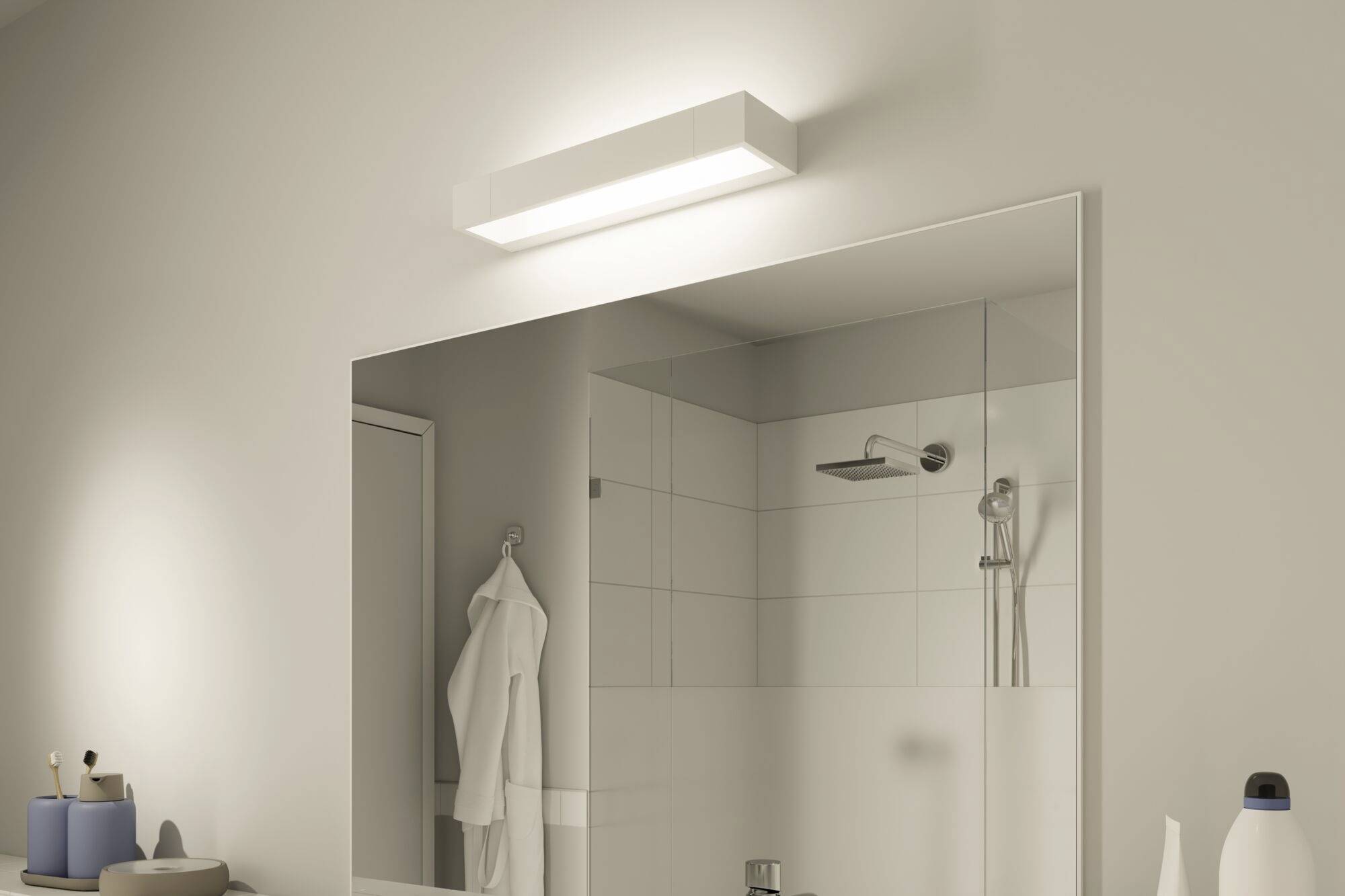 Badezimmer mit beleuchtetem Spiegel, Duschbereich mit Regendusche und weißen Fliesen; links liegen Handtücher und Toilettenartikel.