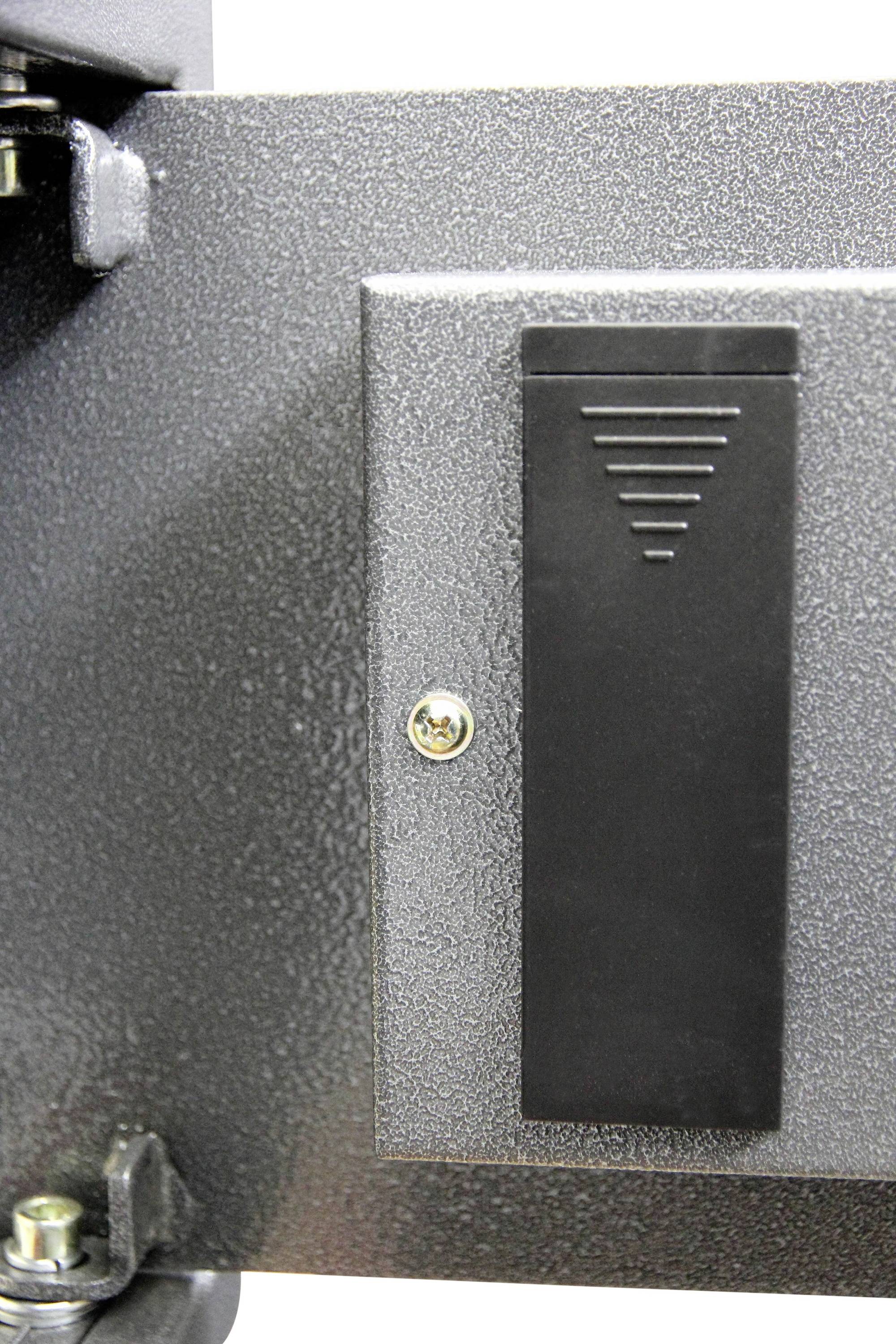 Metallische Oberfläche mit rechteckigem, schwarzen, erhabenen Element und Schraube in der Mitte.