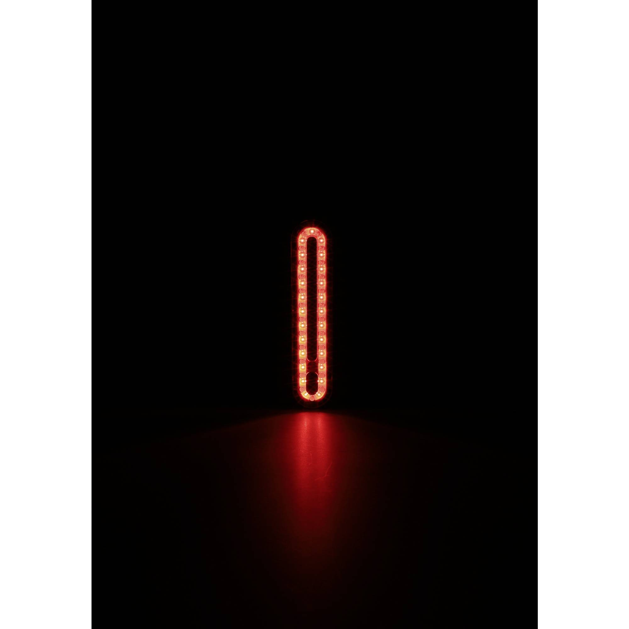 Eine rote, vertikale, ovale LED-Lichtleiste leuchtet in einem dunklen Raum.