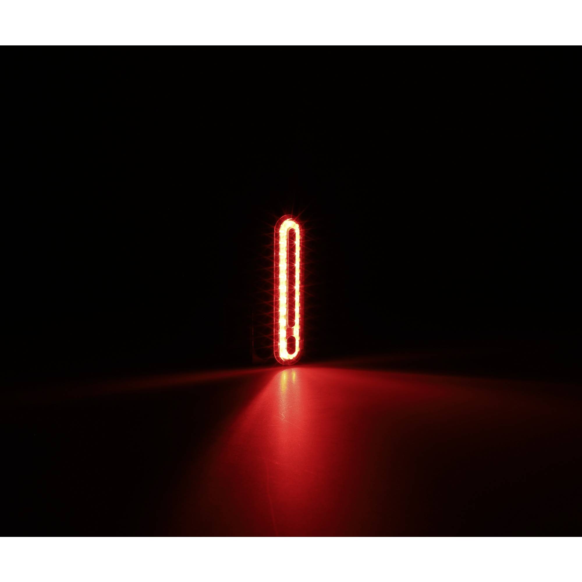 Rotes LED-Licht leuchtet hell in der Dunkelheit, reflektiert leicht auf der Oberfläche darunter.