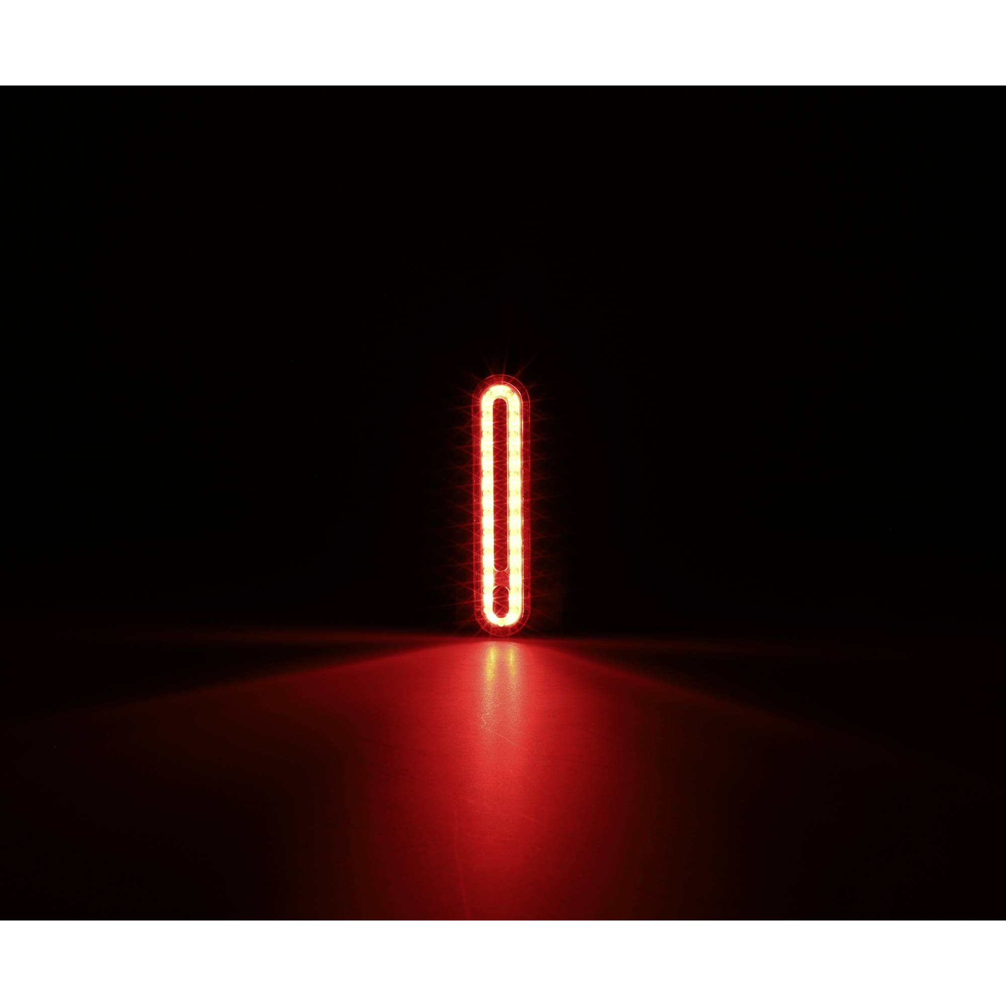 Ein leuchtendes rotes Oval vor einem schwarzen Hintergrund. Es strahlt helles Licht aus und erzeugt eine Spiegelung auf einer Oberfläche.