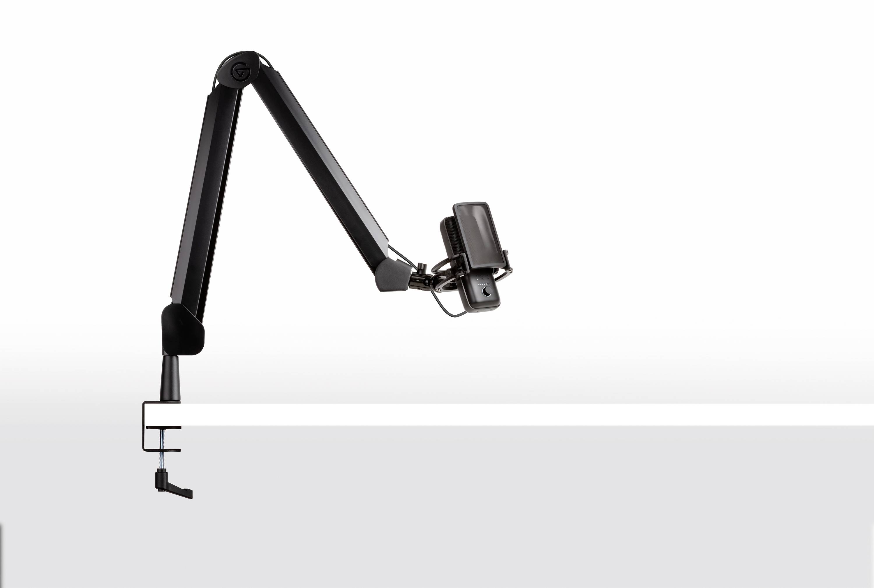 Mikrofonarm aus Metall, der an eine Tischkante geklemmt ist, mit einem Halter für ein Mikrofon, zeigt nach links.