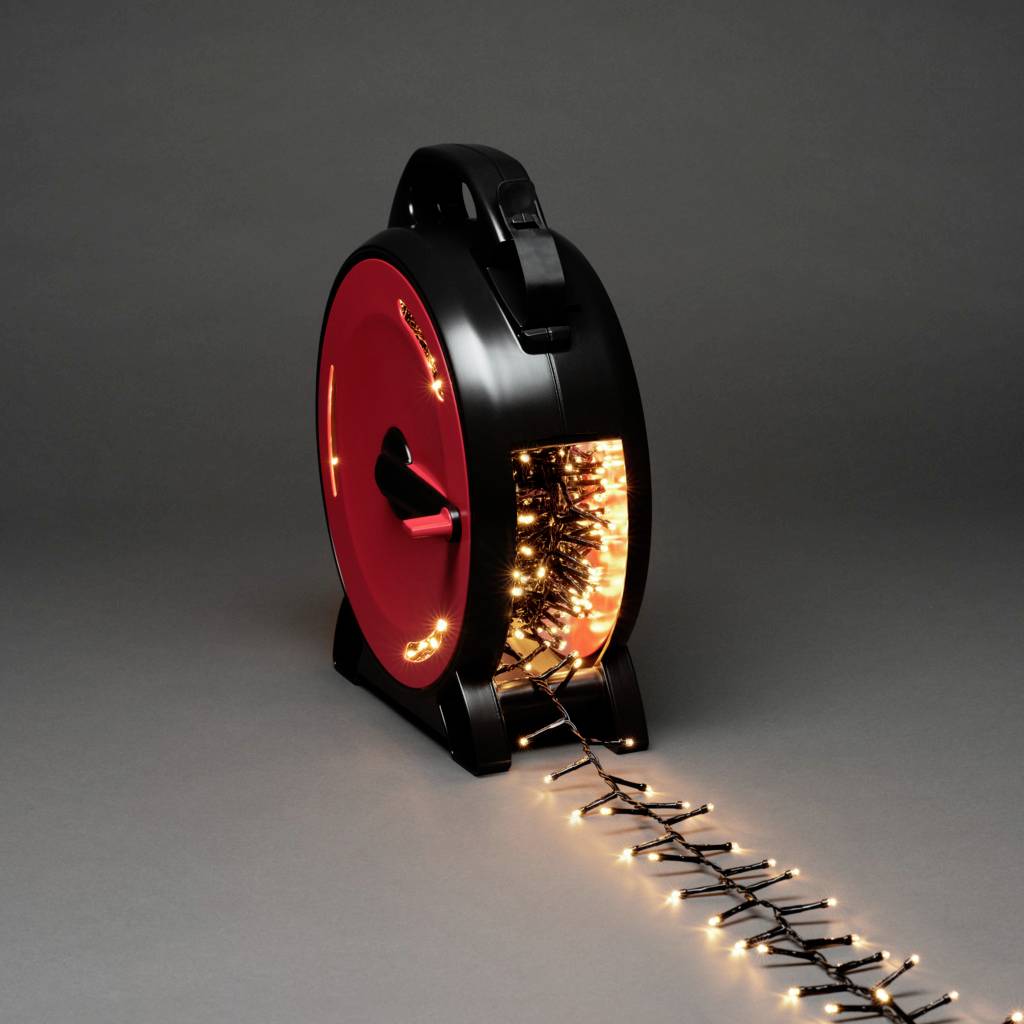 Eine Aufrollvorrichtung mit schwarzen und roten Akzenten, auf der eine Lichterkette aufgerollt ist. Einige Lichter hängen heraus.