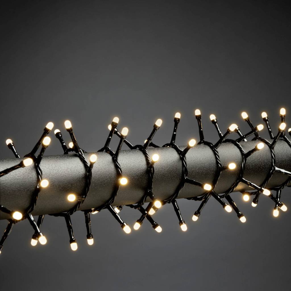 Eine dunkelgraue Stange ist mit einer Lichterkette umwickelt, die warmweiße Lichter zeigt, wodurch ein festlicher Eindruck entsteht.