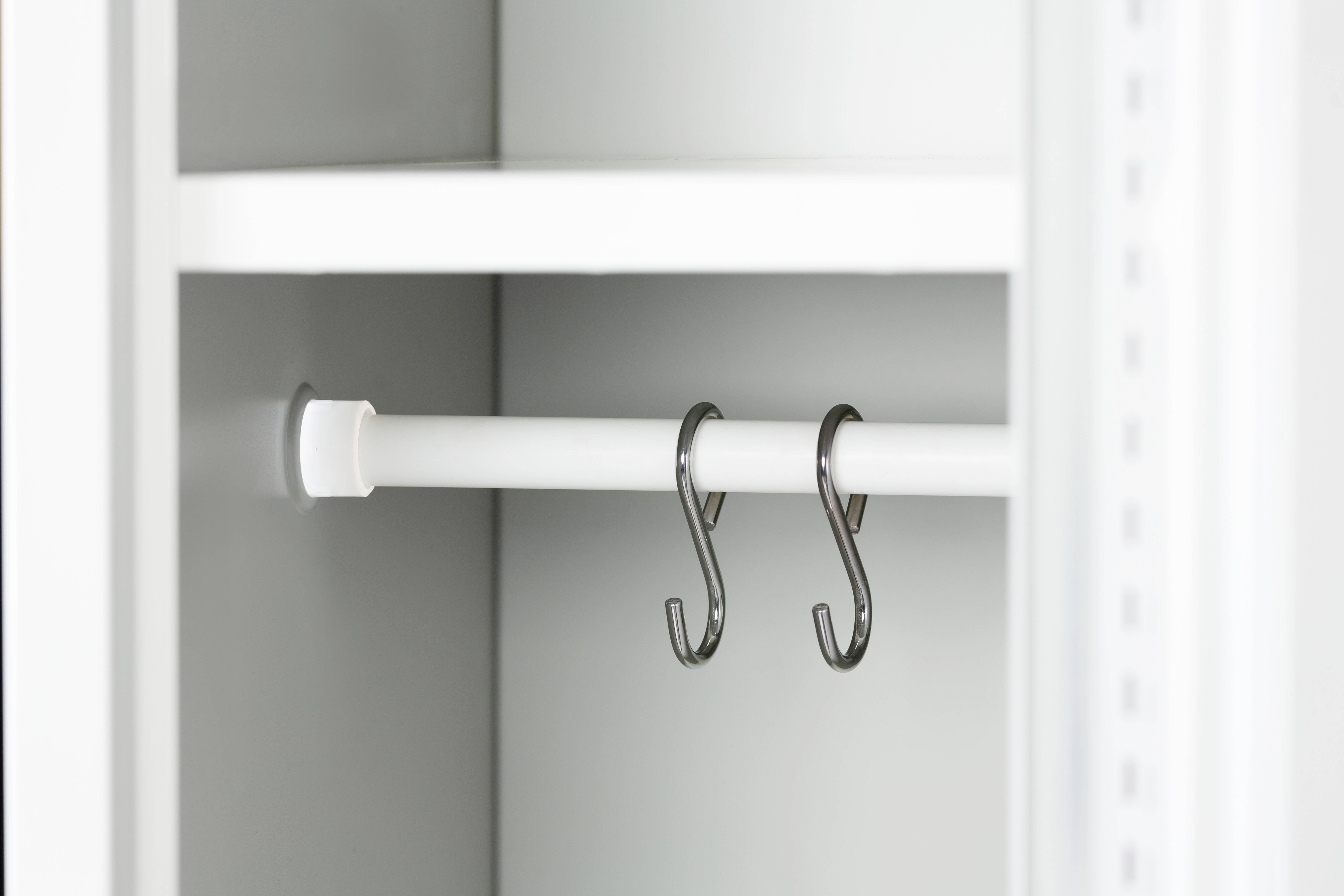 Ein leerer weißer Schrank mit zwei schwarzen Haken an einer Kleiderstange im Inneren.