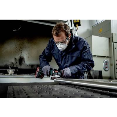 Ein Mann arbeitet mit Schutzbrille und Maske in einer Werkstatt an einer Metallstange mit einem Akkuschrauber.